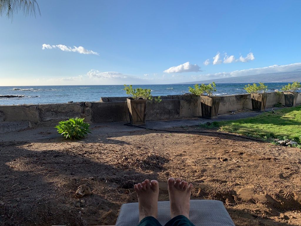 Photo of toes, sea wall, and ocean. A place to be.